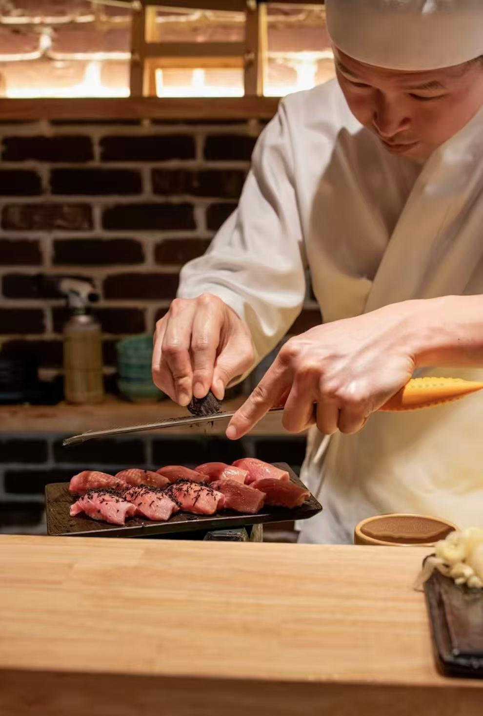 Chef finishing tuna nigiri with seasoning at Kiyoshi Omakase counter Overland Park