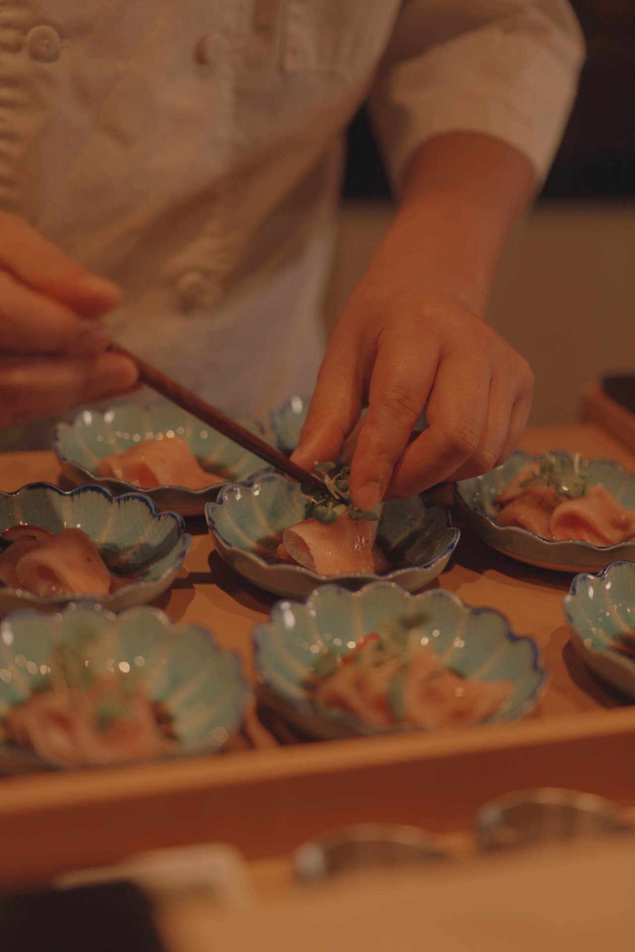 Chef plating sashimi for private event