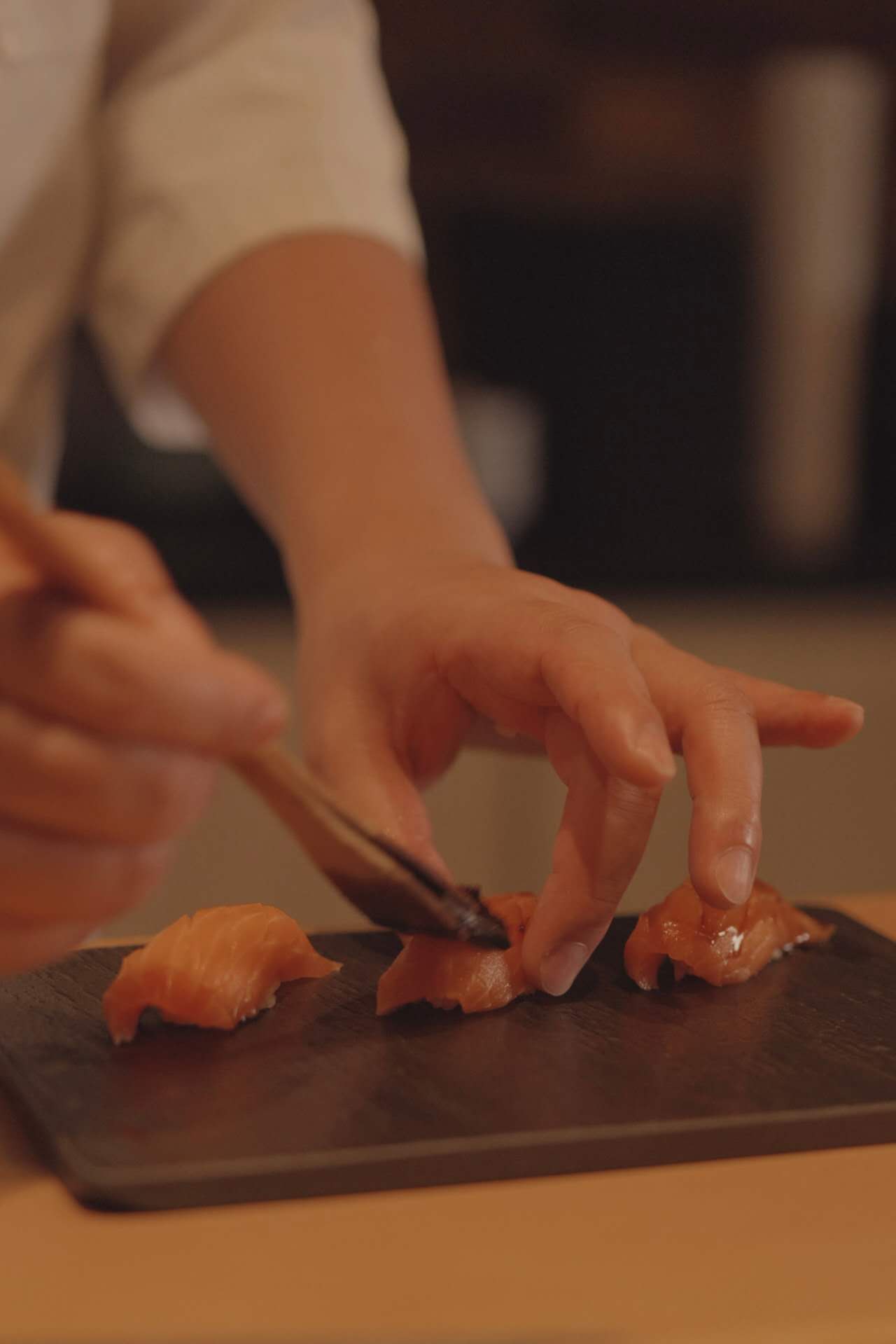 Sushi chef slicing fresh salmon at Kiyoshi Omakase counter in Overland Park