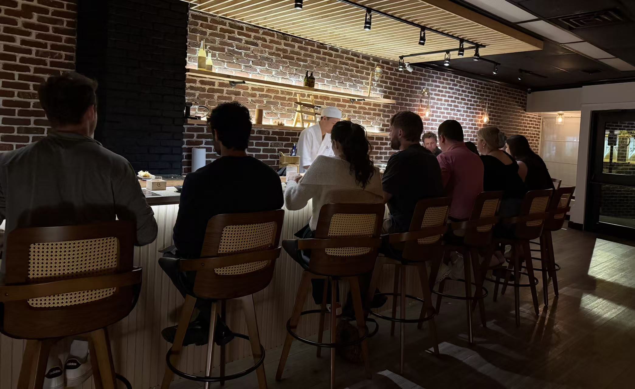 Guests dining at Kiyoshi Omakase counter watching live sushi performance in Overland Park