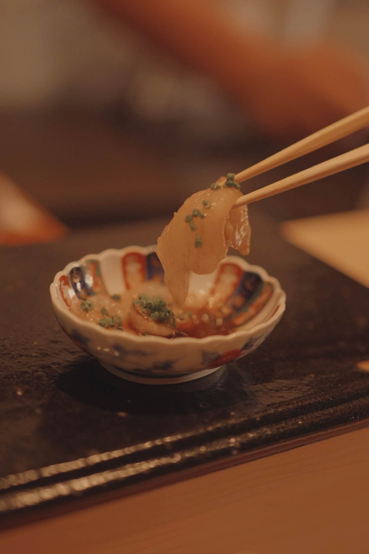 Fresh sashimi with chopsticks and ponzu at Kiyoshi Omakase
