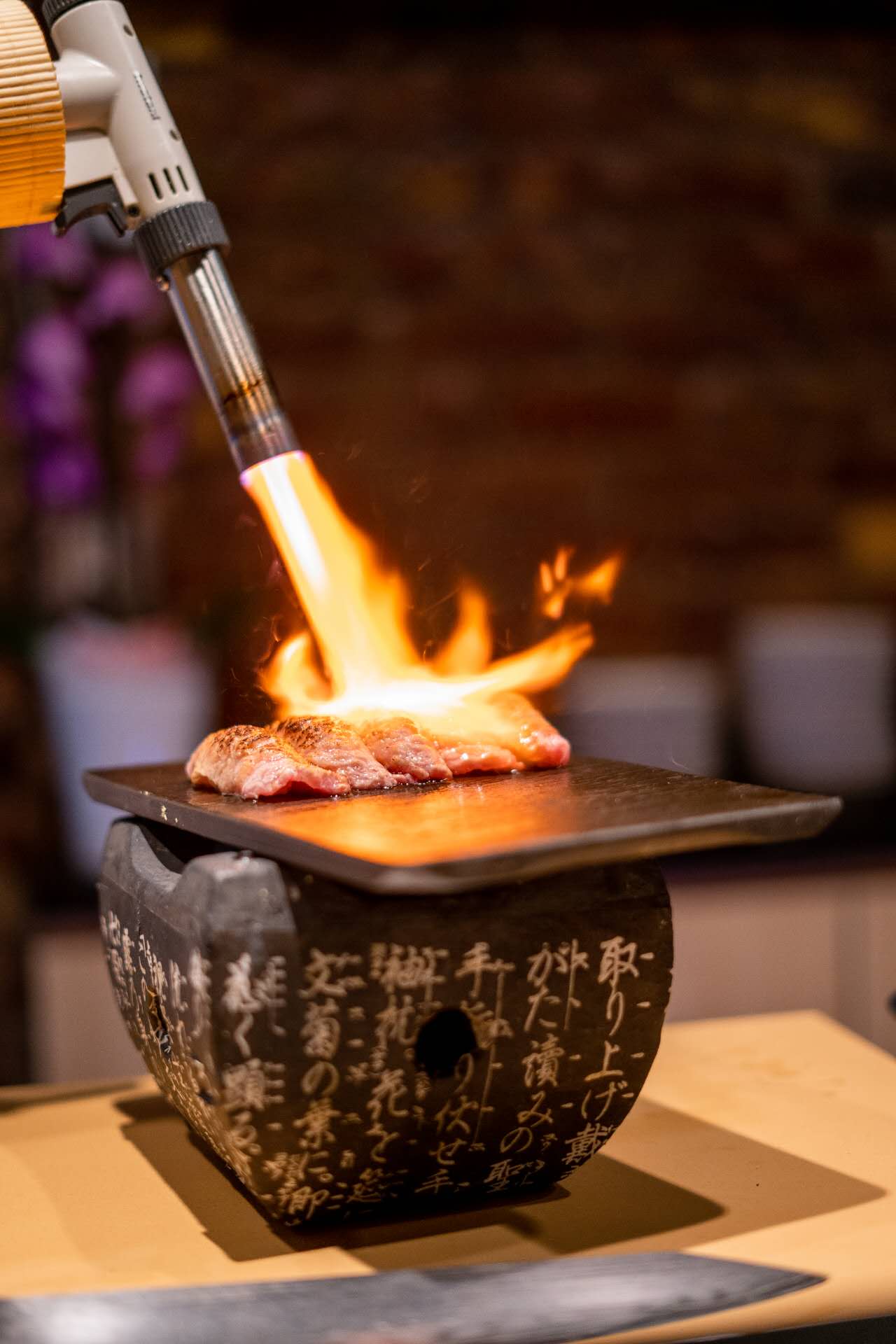 Closeup of chef torching wagyu at Kiyoshi Omakase